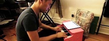 Jovem faz música clássica com tablet e piano infantil